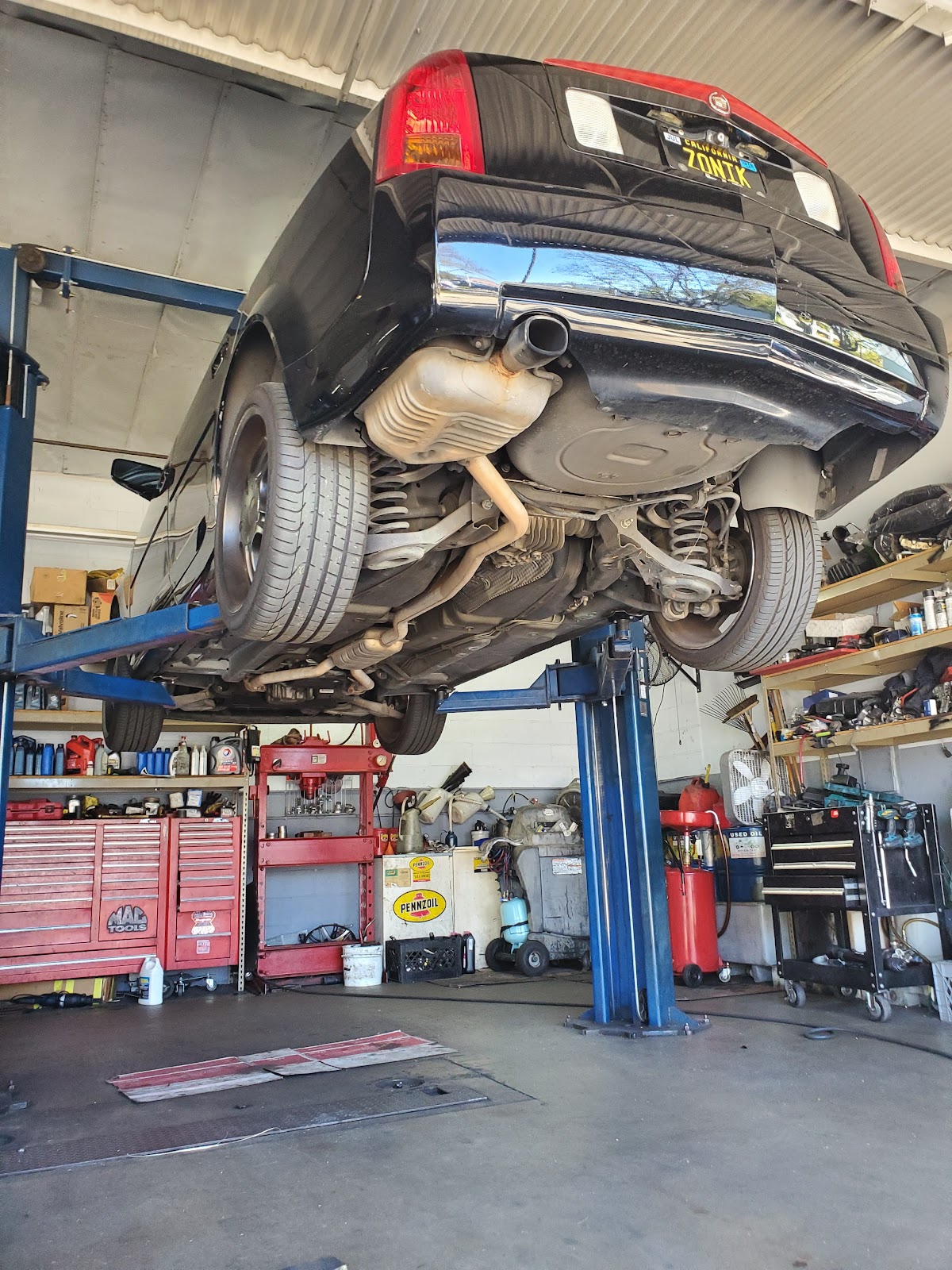 A vehicle up on the lift being serviced